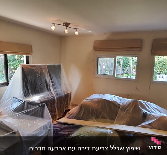 חדר עם רהיטים מכוסים בניילון לקראת שיפוץ